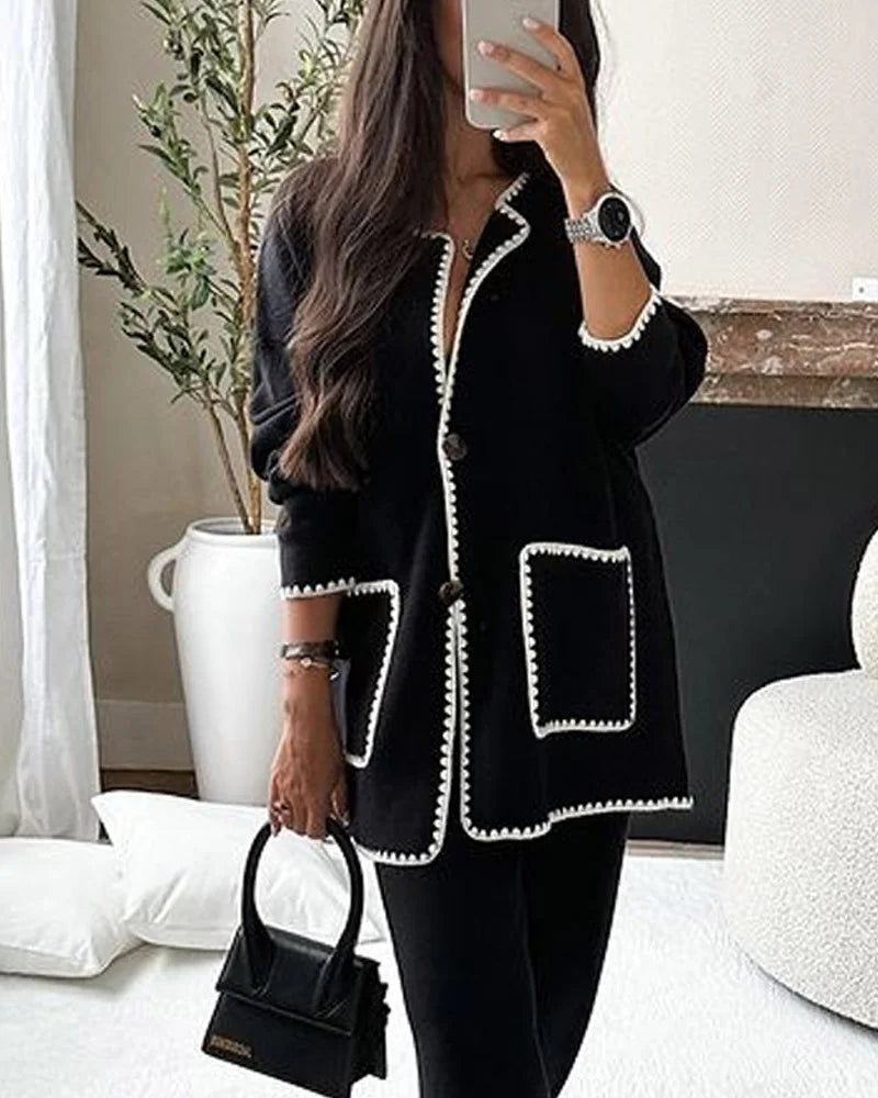 Conjunto de dos piezas compuesto por una chamarra decorada con líneas y un pantalón informal